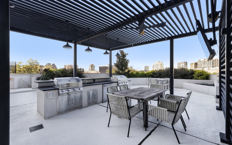 a grill area with a table and chairs